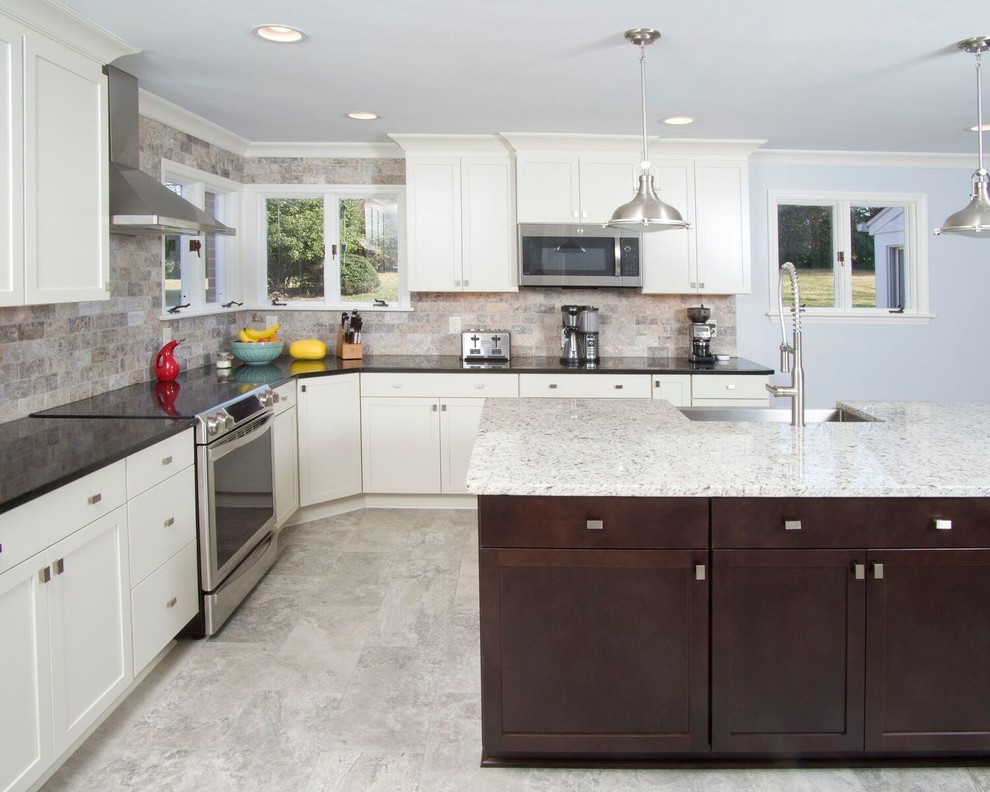 Large transitional u-shaped ceramic tile and gray floor eat-in kitchen photo with a farmhouse sink, white cabinets, granite countertops, multicolored backsplash, subway tile backsplash, stainless steel appliances, an island and shaker cabinets