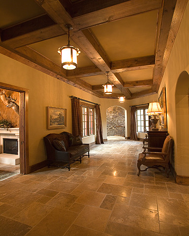 Design ideas for an expansive country foyer in Charlotte with yellow walls, travertine floors, a double front door and a dark wood front door.