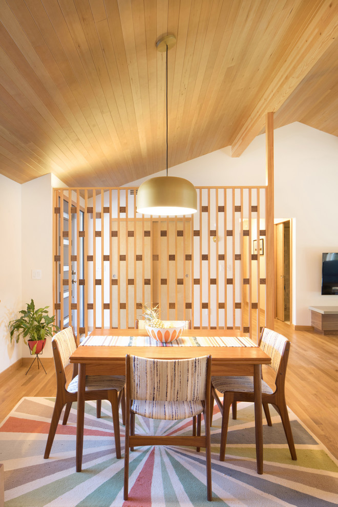 Example of a mid-sized 1950s medium tone wood floor and brown floor great room design in Seattle with white walls