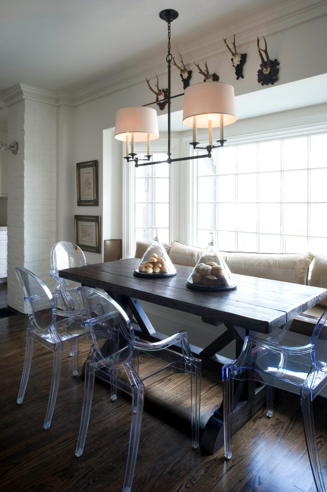 Inspiration for a traditional dining room in Orlando with white walls and dark hardwood floors.