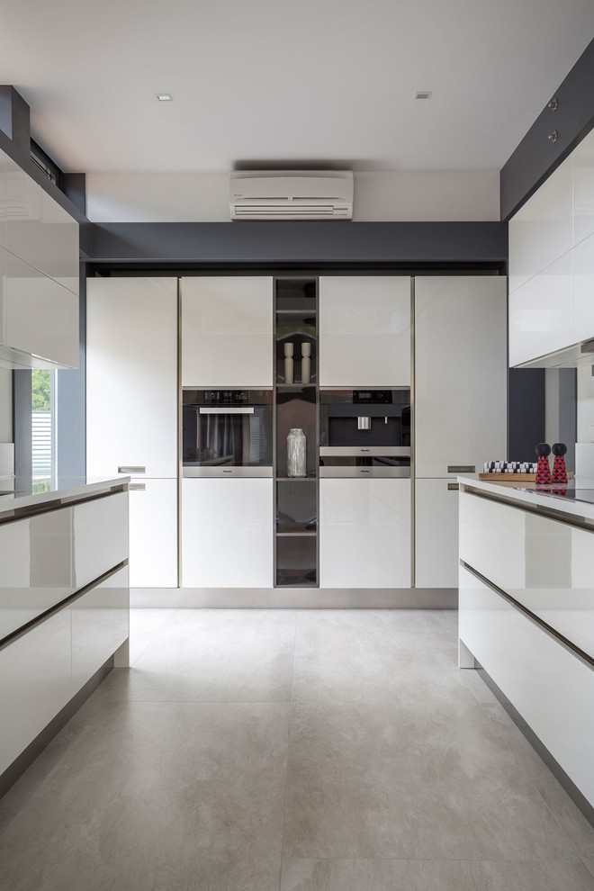 This is an example of a mid-sized contemporary galley separate kitchen in Moscow with an undermount sink, flat-panel cabinets, white cabinets, solid surface benchtops, white splashback, stainless steel appliances, porcelain floors and beige floor.