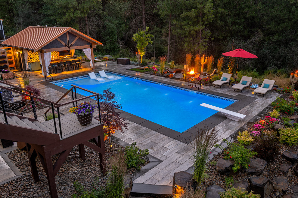 Design ideas for an expansive arts and crafts backyard rectangular lap pool in Seattle with a pool house and natural stone pavers.