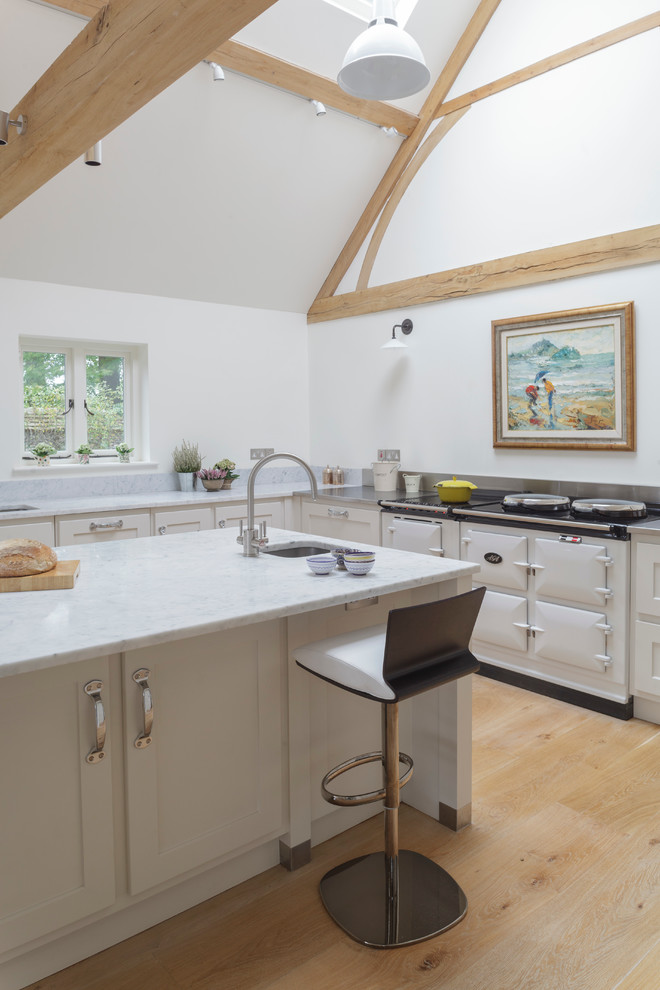Design ideas for a transitional u-shaped open plan kitchen in Wiltshire with shaker cabinets, white cabinets and white appliances.