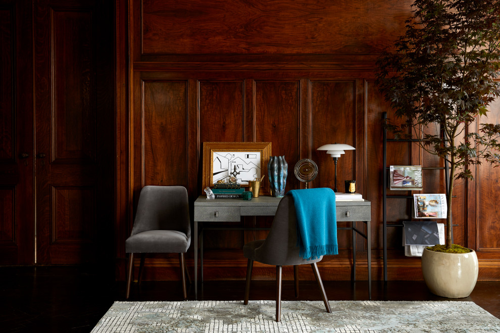 Transitional study room in New York with grey walls, a freestanding desk, brown floor and panelled walls.