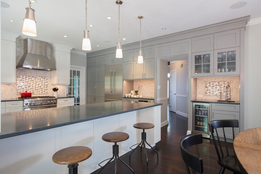 Design ideas for a large transitional u-shaped open plan kitchen in DC Metro with a farmhouse sink, recessed-panel cabinets, grey cabinets, quartz benchtops, white splashback, marble splashback, stainless steel appliances, dark hardwood floors, a peninsula, brown floor and black benchtop.
