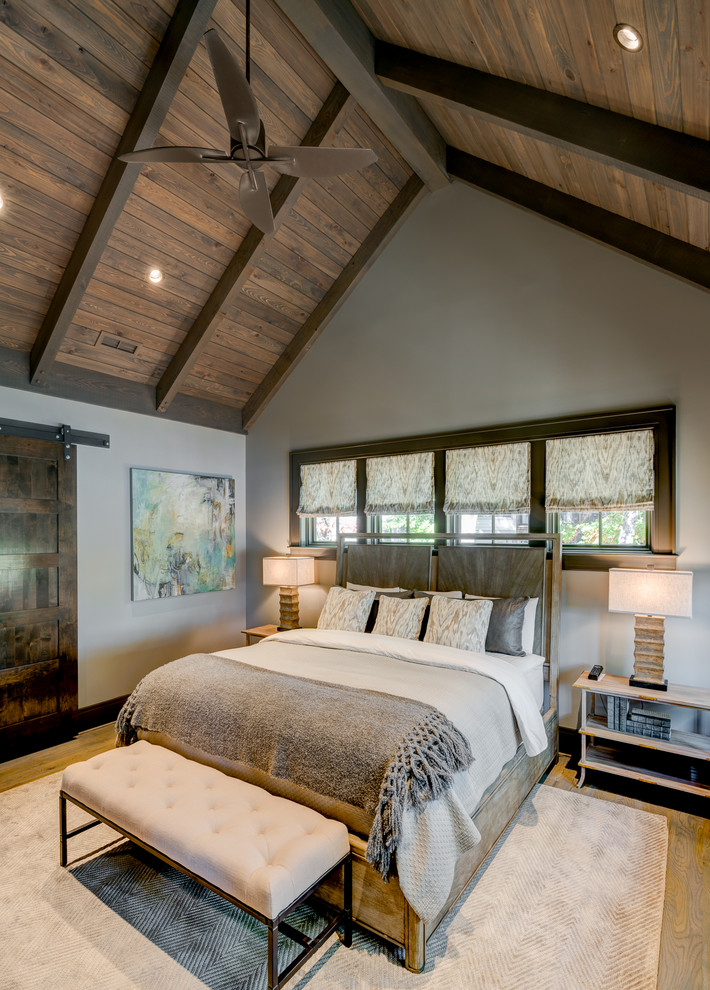 Mountain style medium tone wood floor bedroom photo with gray walls
