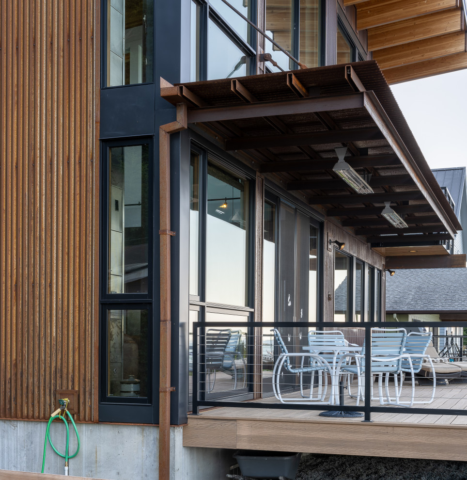 Photo of a medium sized modern back ground level wire cable railing terrace in Seattle with an awning.