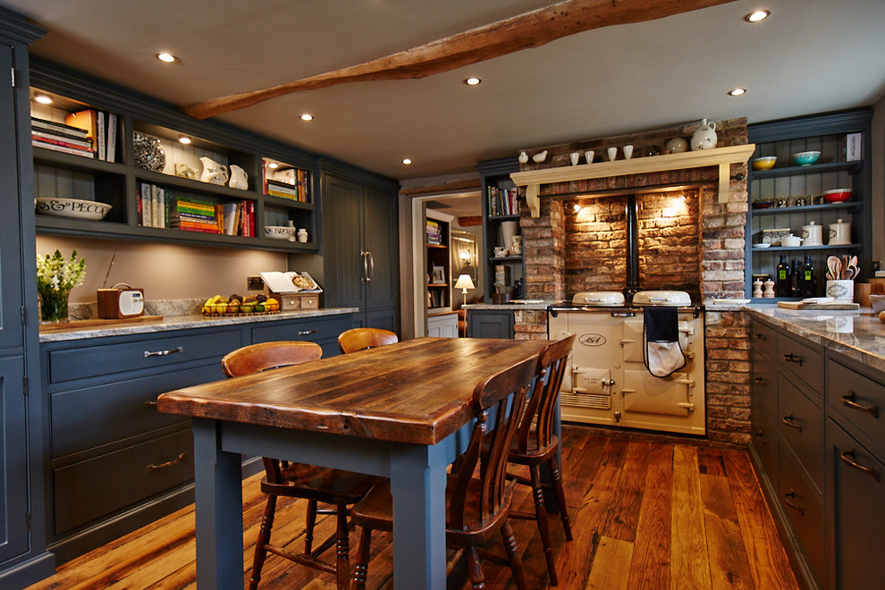 This is an example of a mid-sized traditional eat-in kitchen in Other with recessed-panel cabinets, blue cabinets, brick splashback, medium hardwood floors, no island, brown floor and grey benchtop.