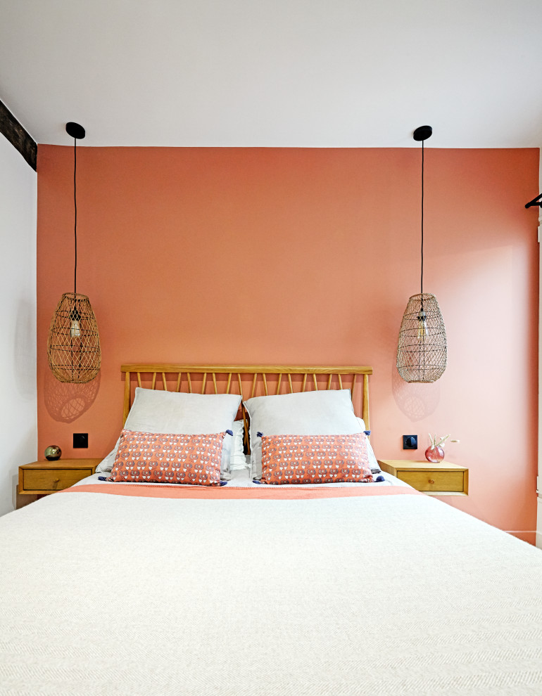 This is an example of a mid-sized traditional master bedroom in Paris with orange walls, light hardwood floors, no fireplace and beige floor.