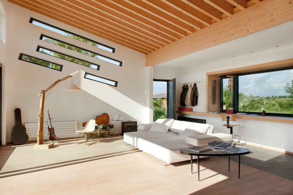 Photo of a large contemporary open concept family room in Lyon with white walls, dark hardwood floors, no tv and brown floor.