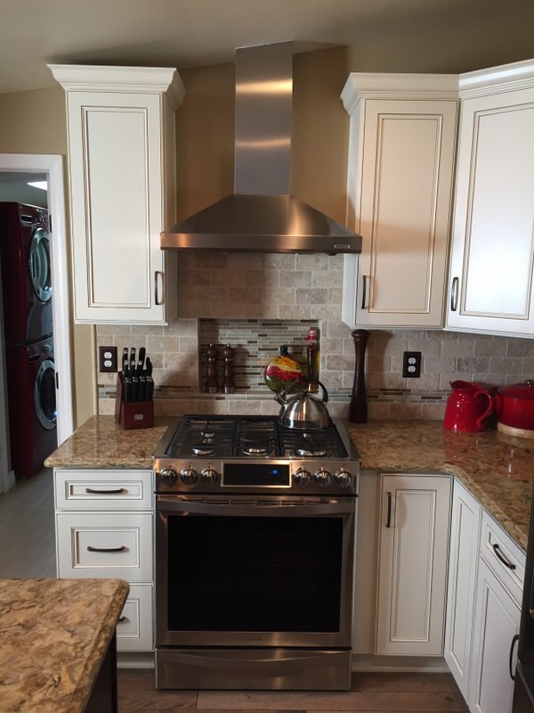 Inspiration for a mid-sized transitional u-shaped medium tone wood floor eat-in kitchen remodel with an undermount sink, flat-panel cabinets, dark wood cabinets, quartz countertops, beige backsplash, stone tile backsplash, stainless steel appliances and an island