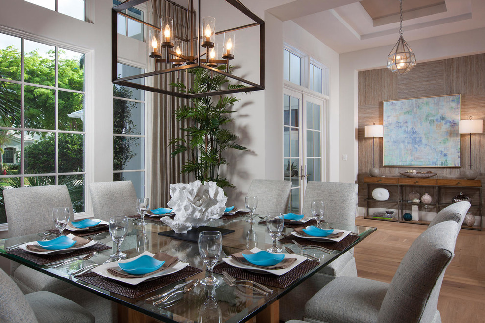 This is an example of a transitional dining room in Miami with white walls and light hardwood floors.