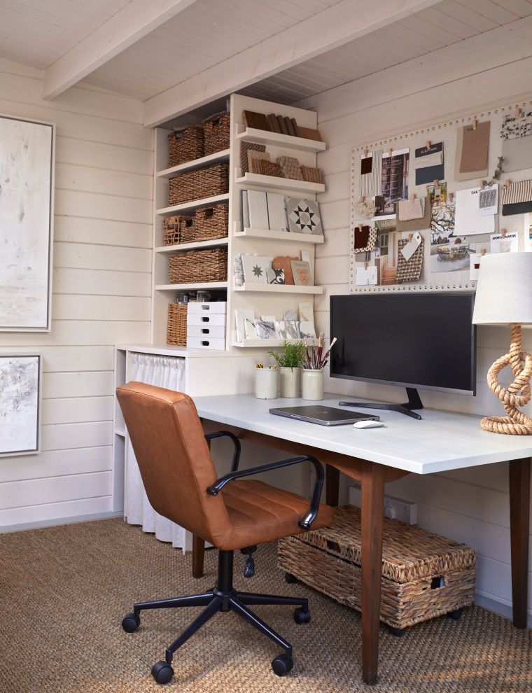Modelo de estudio campestre de tamaño medio con paredes blancas, moqueta, escritorio independiente y vigas vistas