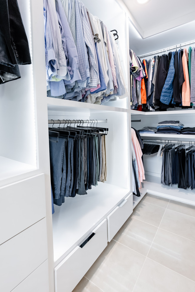 Design ideas for a mid-sized modern men's storage and wardrobe in Houston with beaded inset cabinets, white cabinets, porcelain floors and beige floor.