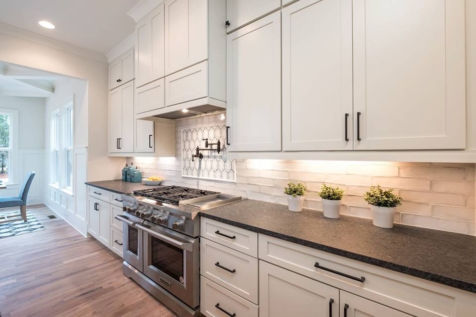 Eclectic kitchen photo with a farmhouse sink and solid surface countertops
