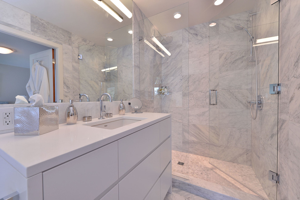 This is an example of a small modern master bathroom in Vancouver with flat-panel cabinets, white cabinets, multi-coloured tile, an undermount sink, engineered quartz benchtops, a drop-in tub, an alcove shower, a one-piece toilet, stone tile, white walls and marble floors.