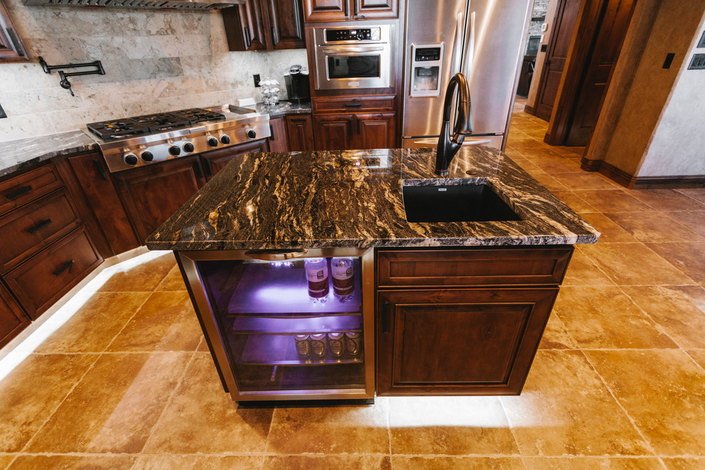 Inspiration for a transitional kitchen remodel with a drop-in sink, dark wood cabinets, quartz countertops, beige backsplash, custom tile backsplash, stainless steel appliances, beige walls and an island