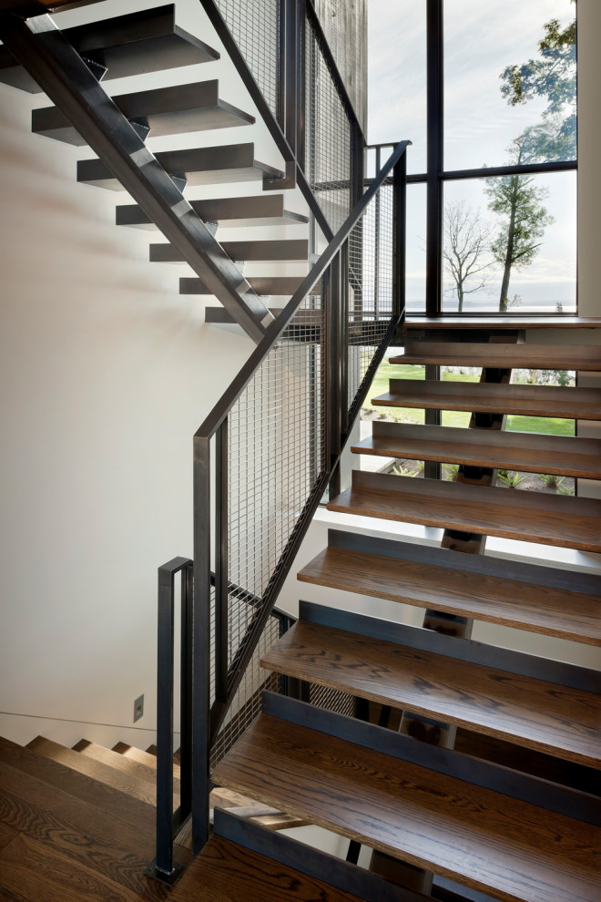 На фото: металлическая лестница в стиле кантри с деревянными ступенями и металлическими перилами с