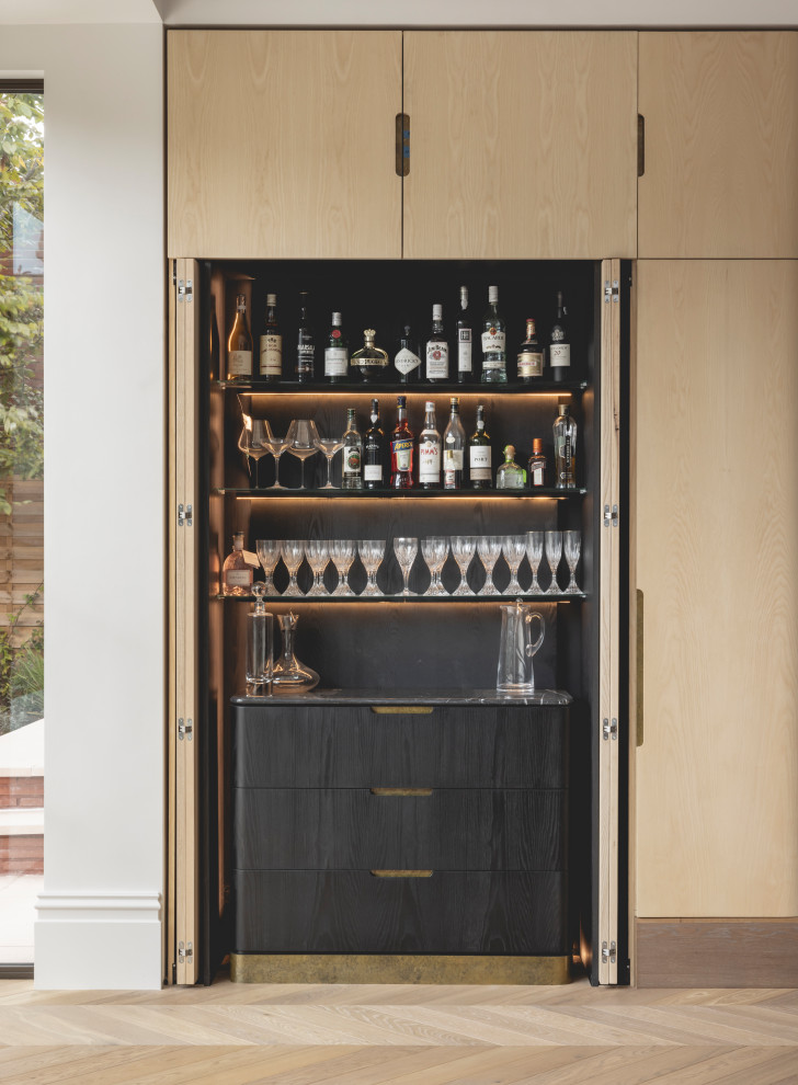 Design ideas for a contemporary single-wall dry bar in London with flat-panel cabinets, black cabinets, grey splashback, stone slab splashback, light hardwood flooring, beige floors and grey worktops.