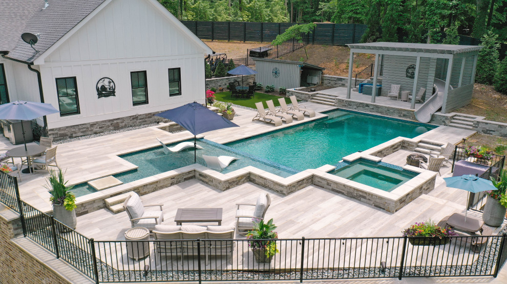 Пример оригинального дизайна: большой ландшафтный бассейн на заднем дворе в стиле модернизм