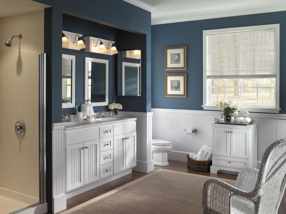 Alcove shower - mid-sized transitional master dark wood floor and brown floor alcove shower idea with shaker cabinets, white cabinets, a one-piece toilet, blue walls, an integrated sink and a hinged shower door
