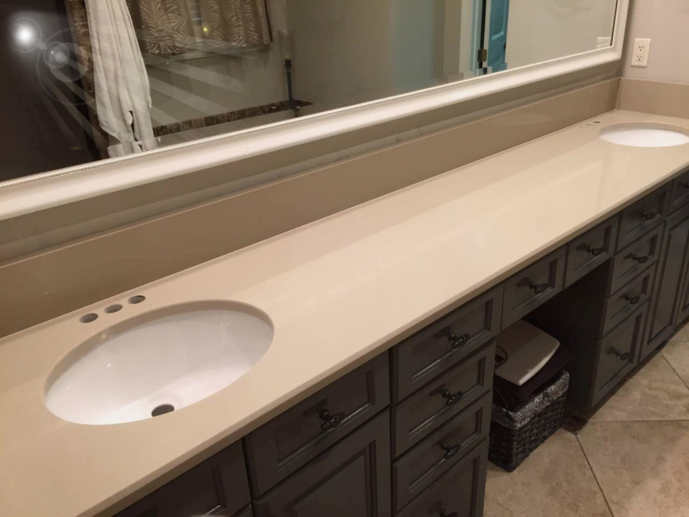 Bathroom - transitional ceramic tile and beige floor bathroom idea in Birmingham with raised-panel cabinets, black cabinets, beige walls, an undermount sink and quartzite countertops