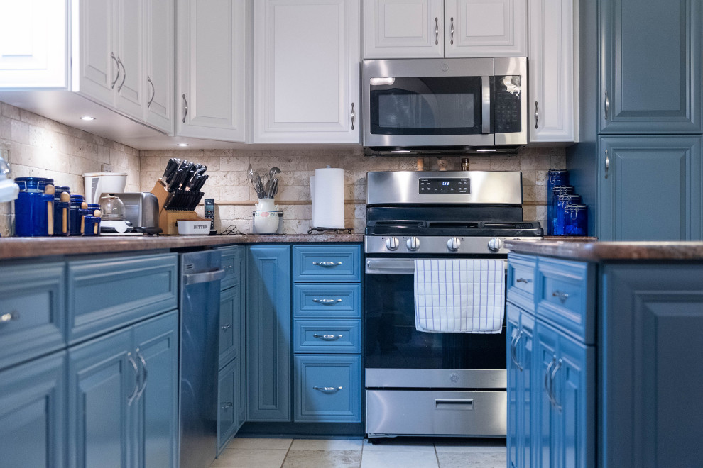 ボルチモアにある中くらいなトランジショナルスタイルのおしゃれなキッチン (アンダーカウンターシンク、落し込みパネル扉のキャビネット、青いキャビネット、御影石カウンター、ベージュキッチンパネル、石タイルのキッチンパネル、シルバーの調理設備、セラミックタイルの床、ベージュの床、オレンジのキッチンカウンター) の写真