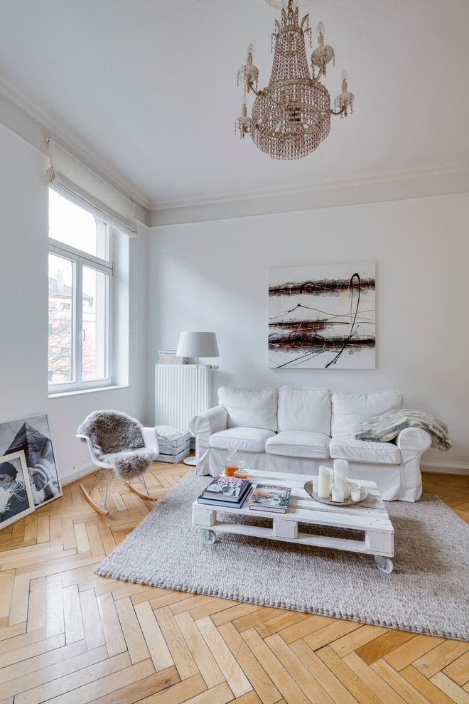 This is an example of a mid-sized scandinavian enclosed living room in Cologne with white walls, light hardwood floors and no fireplace.