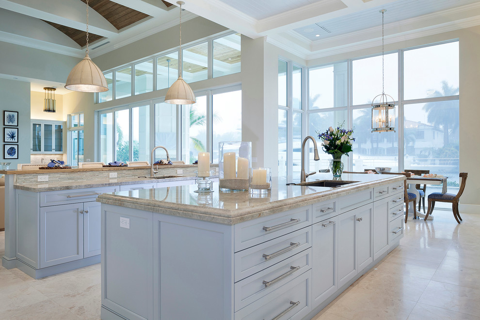 Inspiration for a large transitional u-shaped ceramic tile and beige floor open concept kitchen remodel in Miami with an undermount sink, recessed-panel cabinets, white cabinets, marble countertops, multicolored backsplash, subway tile backsplash, stainless steel appliances, two islands and beige countertops