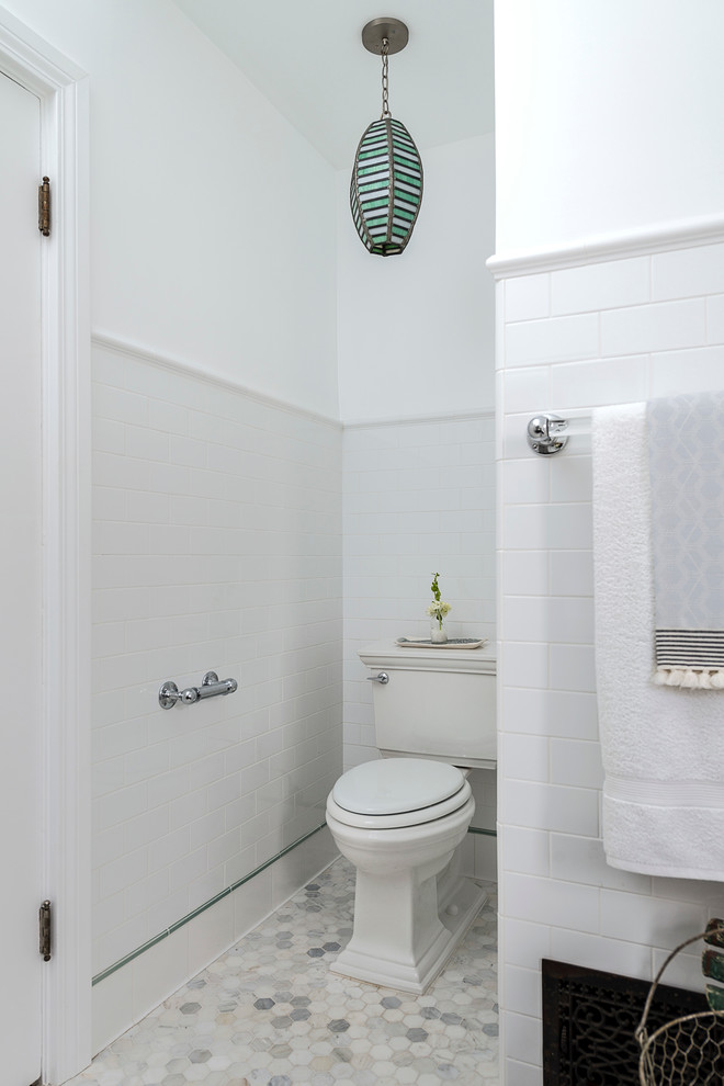 Small transitional master bathroom in Los Angeles with a drop-in sink, flat-panel cabinets, solid surface benchtops, an undermount tub, a shower/bathtub combo, a two-piece toilet, white tile, subway tile, white walls and marble floors.