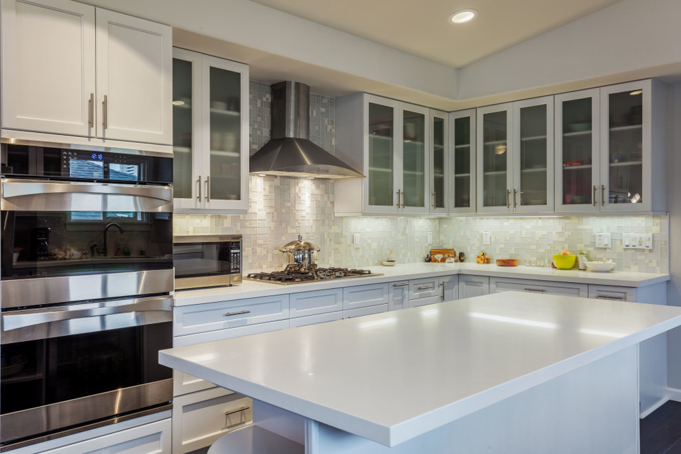 Photo of a large transitional u-shaped separate kitchen in Hawaii with an undermount sink, shaker cabinets, white cabinets, quartz benchtops, white splashback, stone tile splashback, stainless steel appliances, dark hardwood floors and with island.