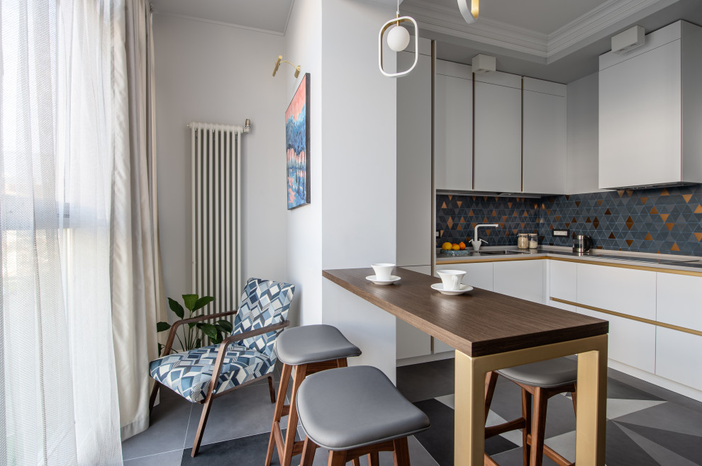 Photo of a large scandinavian l-shaped eat-in kitchen in Other with an undermount sink, flat-panel cabinets, white cabinets, solid surface benchtops, multi-coloured splashback, ceramic splashback, white appliances, ceramic floors, no island, grey floor, grey benchtop and recessed.
