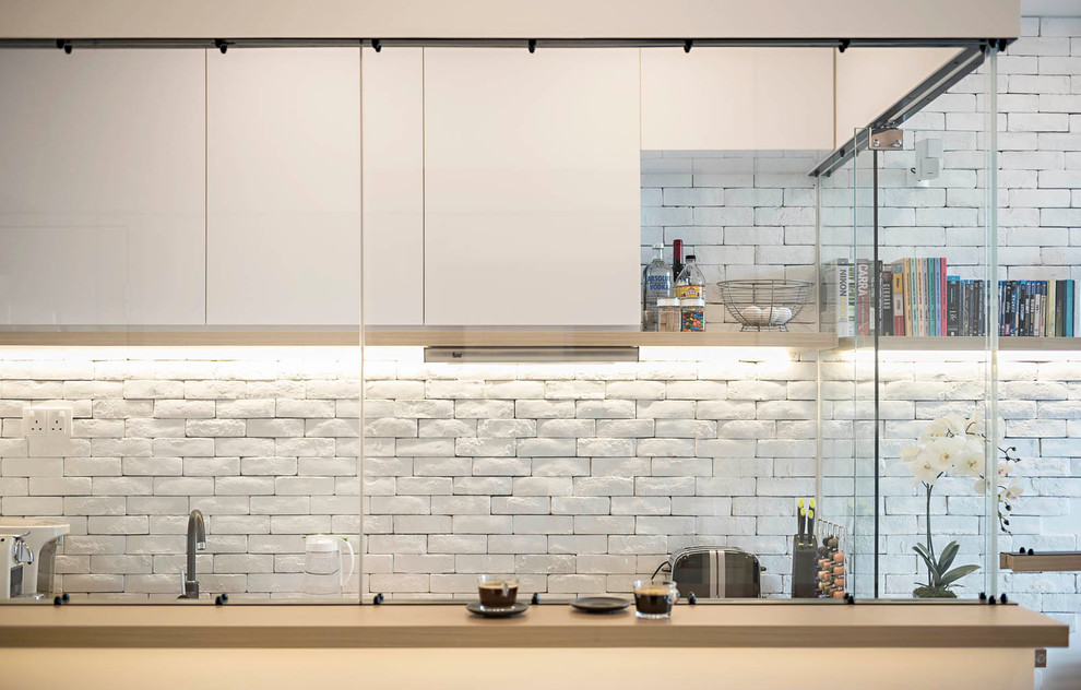 Small contemporary single-wall separate kitchen in Singapore with a single-bowl sink, white splashback, stone tile splashback, stainless steel appliances, ceramic floors and no island.