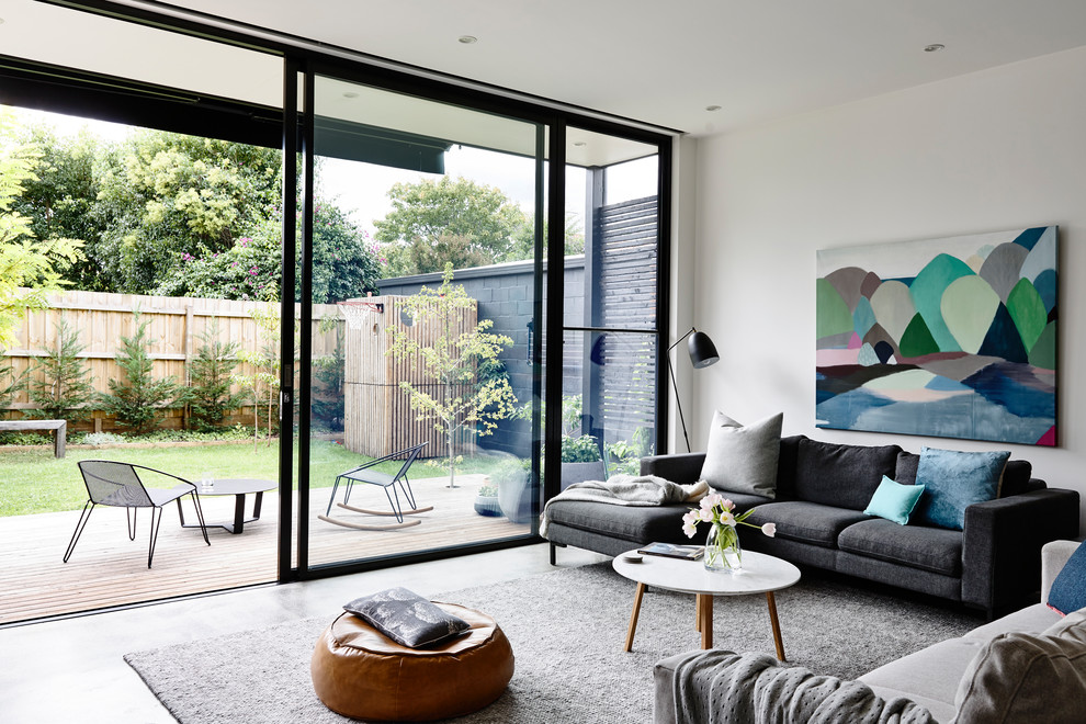 Contemporary living room in Melbourne with white walls and grey floor.