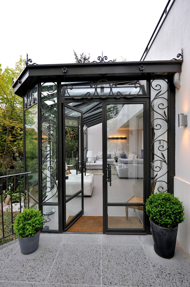 Inspiration for a mid-sized traditional sunroom in Paris with ceramic floors and a glass ceiling.