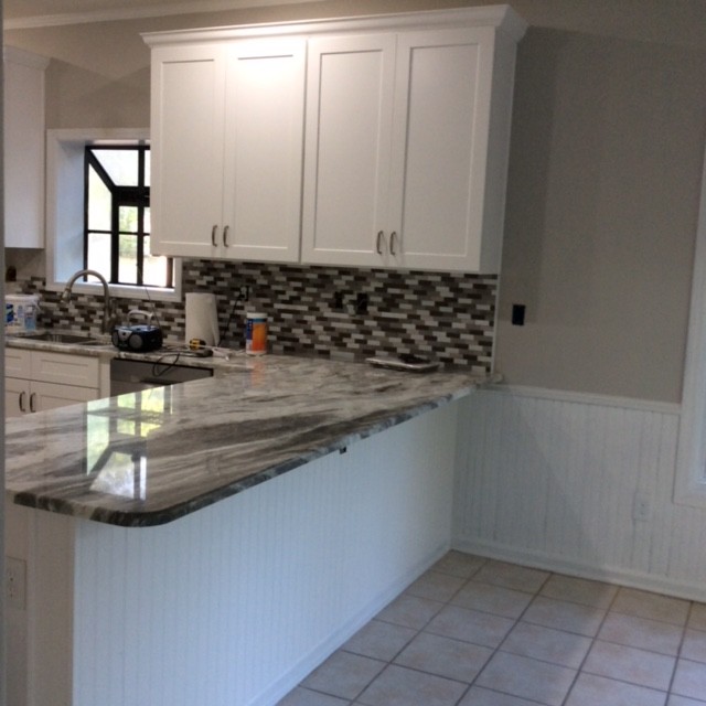 Enclosed kitchen - mid-sized transitional u-shaped ceramic tile enclosed kitchen idea with an undermount sink, recessed-panel cabinets, white cabinets, granite countertops, gray backsplash, stainless steel appliances, an island and white countertops