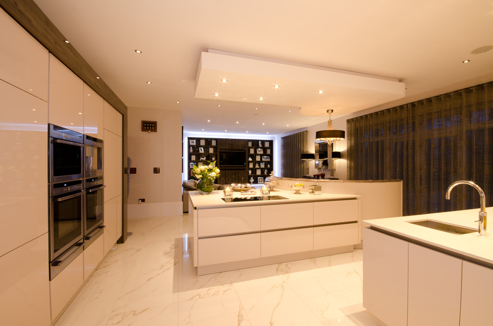 Inspiration for an expansive contemporary l-shaped open plan kitchen in West Midlands with a double-bowl sink, flat-panel cabinets, white cabinets, quartzite benchtops, stainless steel appliances, porcelain floors and with island.