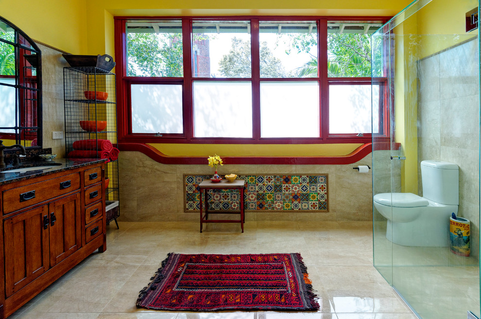 This is an example of a mediterranean bathroom in Melbourne with an undermount sink, medium wood cabinets, a curbless shower, a two-piece toilet, beige tile and recessed-panel cabinets.