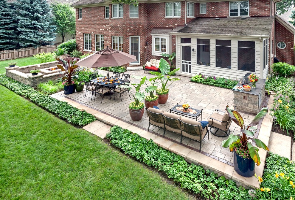 This is an example of a large traditional backyard patio in Chicago with a fire feature, no cover and brick pavers.