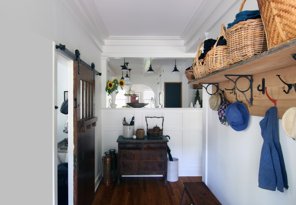 Design ideas for a mid-sized country mudroom in Detroit with white walls, dark hardwood floors and brown floor.