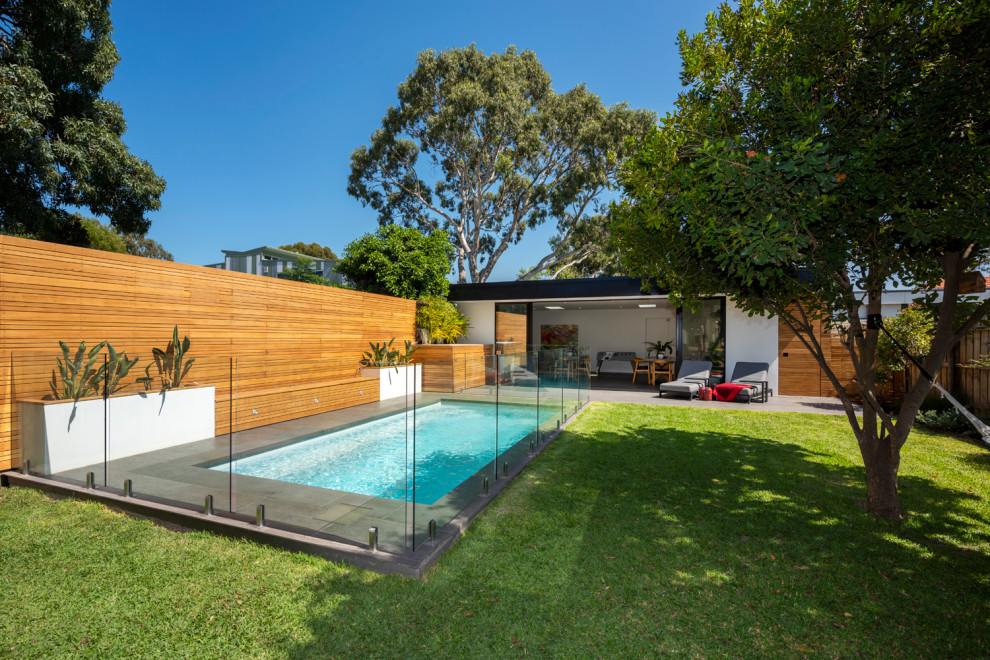 Mid-sized contemporary backyard partial sun garden in Melbourne with with raised garden bed and natural stone pavers.