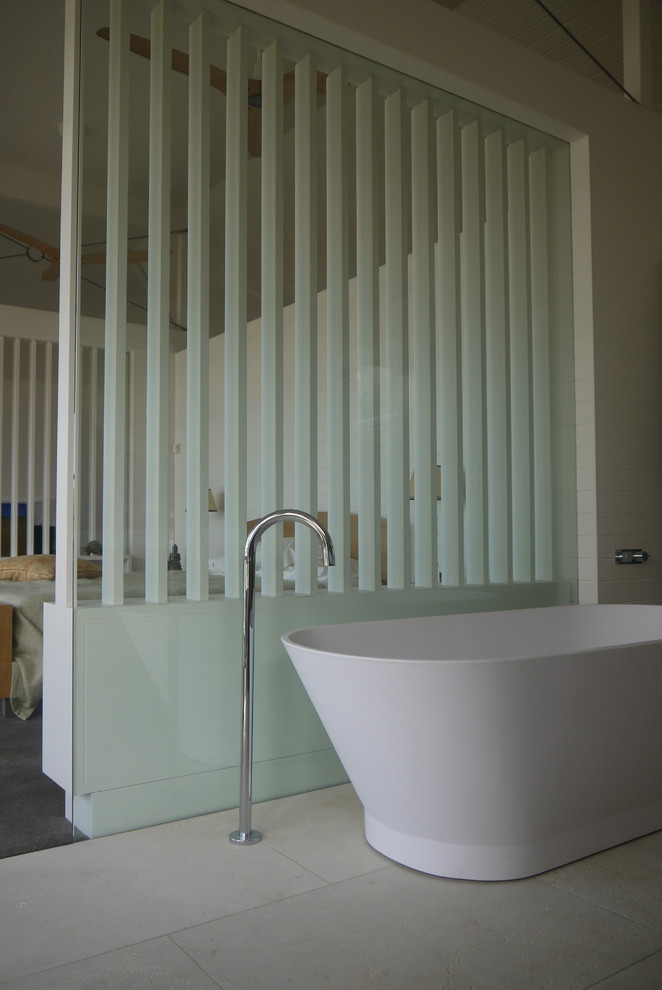 Inspiration for a small beach style kids bathroom in Sydney with recessed-panel cabinets, white cabinets, a freestanding tub, an open shower, a wall-mount toilet, beige tile, limestone, limestone floors, a wall-mount sink, marble benchtops, beige floor and white benchtops.