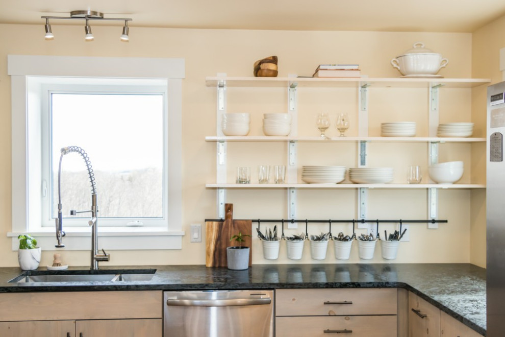 Mid-sized l-shaped cork floor and brown floor kitchen photo with light wood cabinets, stainless steel appliances, black countertops, an undermount sink, flat-panel cabinets, quartzite countertops and an island