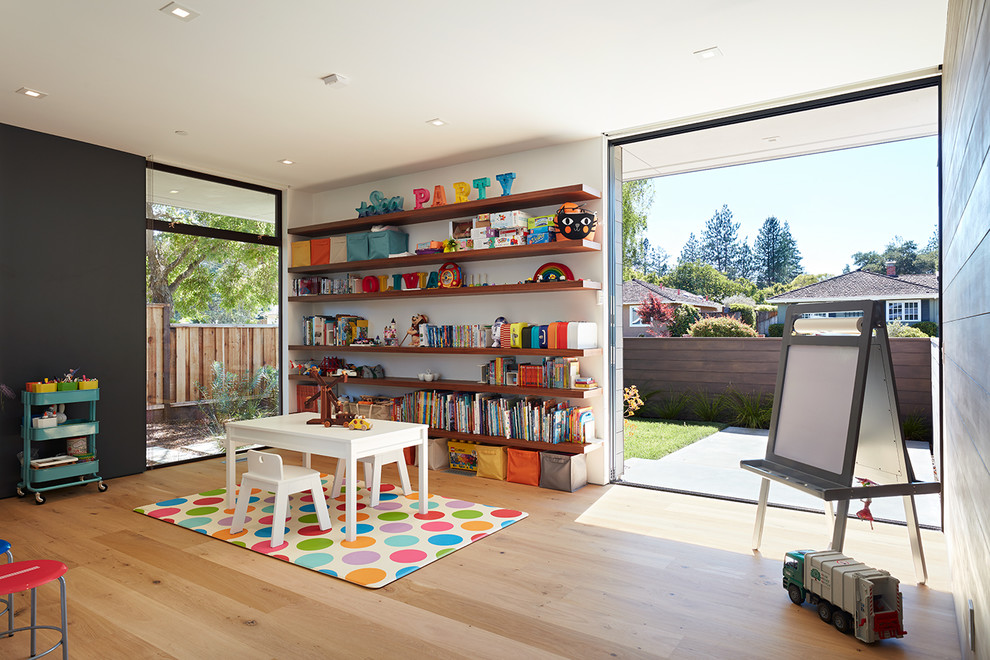 Los Altos New Residence - Klopf Architecture and Outer space Landscape Architects designed a new warm, modern, open, indoor-outdoor home in Los Altos, California. Inspired by mid-century modern homes but looking for something completely new and custom, the owners, a couple with two children, bought an older ranch style home with the intention of replacing it. 

Created on a grid, the house is designed to be at rest with differentiated spaces for activities; living, playing, cooking, dining and a piano space. The low-sloping gable roof over the great room brings a grand feeling to the space. The clerestory windows at the high sloping roof make the grand space light and airy. 
Upon entering the house, an open atrium entry in the middle of the house provides light and nature to the great room. The Heath tile wall at the back of the atrium blocks direct view of the rear yard from the entry door for privacy. 
The bedrooms, bathrooms, play room and the sitting room are under flat wing-like roofs that balance on either side of the low sloping gable roof of the main space. Large sliding glass panels and pocketing glass doors foster openness to the front and back yards. In the front there is a fenced-in play space connected to the play room, creating an indoor-outdoor play space that could change in use over the years. The play room can also be closed off from the great room with a large pocketing door. In the rear, everything opens up to a deck overlooking a pool where the family can come together outdoors.
Wood siding travels from exterior to interior, accentuating the indoor-outdoor nature of the house. Where the exterior siding doesn’t come inside, a palette of white oak floors, white walls, walnut cabinetry, and dark window frames ties all the spaces together to create a uniform feeling and flow throughout the house. The custom cabinetry matches the minimal joinery of the rest of the house, a trim-less, minimal appearance. Wood siding was mitered in the corners, including where siding meets the interior drywall. Wall materials were held up off the floor with a minimal reveal. This tight detailing gives a sense of cleanliness to the house. 
The garage door of the house is completely flush and of the same material as the garage wall, de-emphasizing the garage door and making the street presentation of the house kinder to the neighborhood.
The house is akin to a custom, modern-day Eichler home in many ways. Inspired by mid-century modern homes with today’s materials, approaches, standards, and technologies. The goals were to create an indoor-outdoor home that was energy-efficient, light and flexible for young children to grow. This 3,000 square foot, 3 bedroom, 2.5 bathroom new house is located in Los Altos in the heart of the Silicon Valley. 


Klopf Architecture Project Team: John Klopf, AIA, and Chuang-Ming Liu
 Landscape Architect: Outer space Landscape Architects
 Structural Engineer: ZFA Structural Engineers
 Staging: Da Lusso Design 
 Photography ©2018 Mariko Reed
 Location: Los Altos, CA 
Year completed: 2017