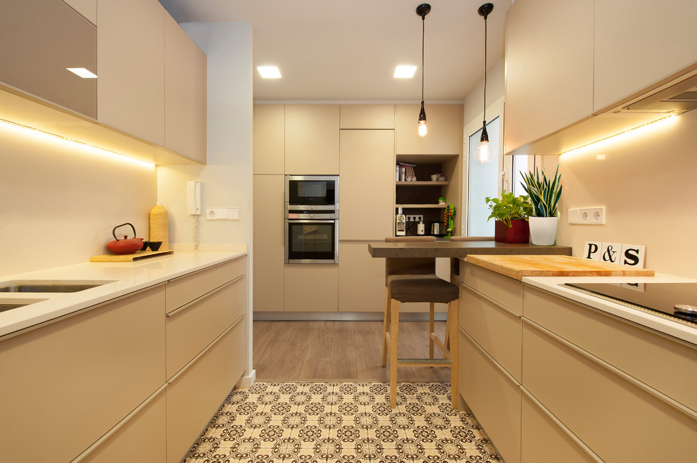 Design ideas for a mid-sized modern galley separate kitchen with recessed-panel cabinets, beige cabinets, beige splashback, a peninsula, a double-bowl sink, stainless steel appliances, ceramic floors and multi-coloured floor.