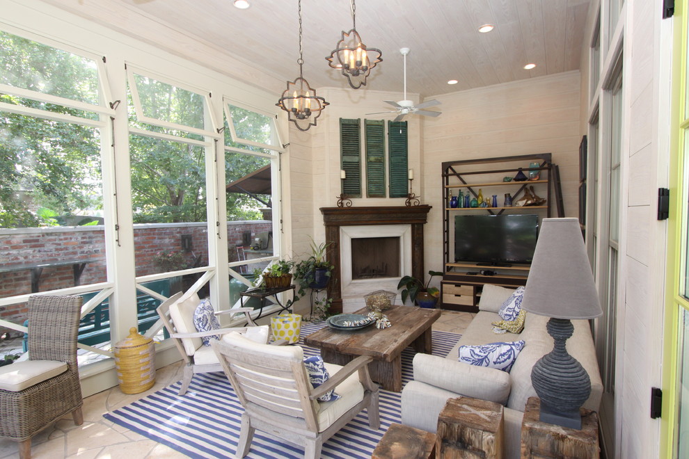 This is an example of a mid-sized country sunroom in New Orleans with a corner fireplace, a wood fireplace surround, a standard ceiling and beige floor.