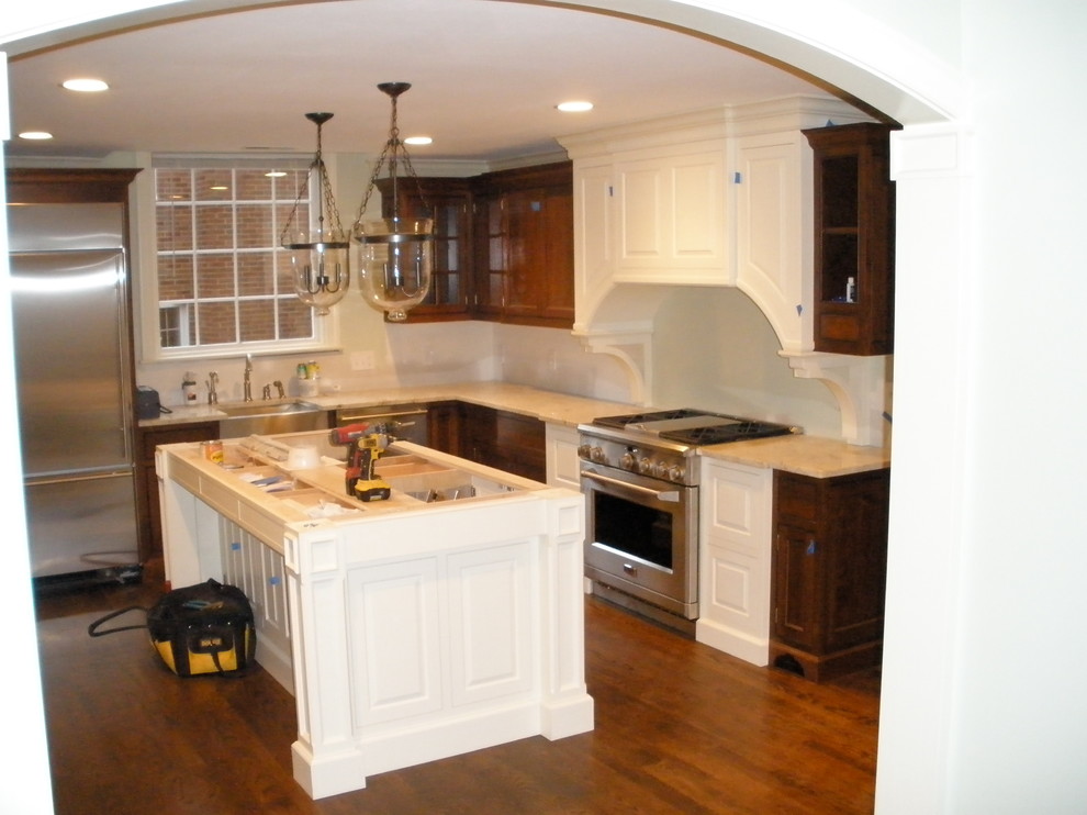 Design ideas for a mid-sized traditional l-shaped eat-in kitchen in Cleveland with beaded inset cabinets, white cabinets, granite benchtops, stainless steel appliances, medium hardwood floors and with island.