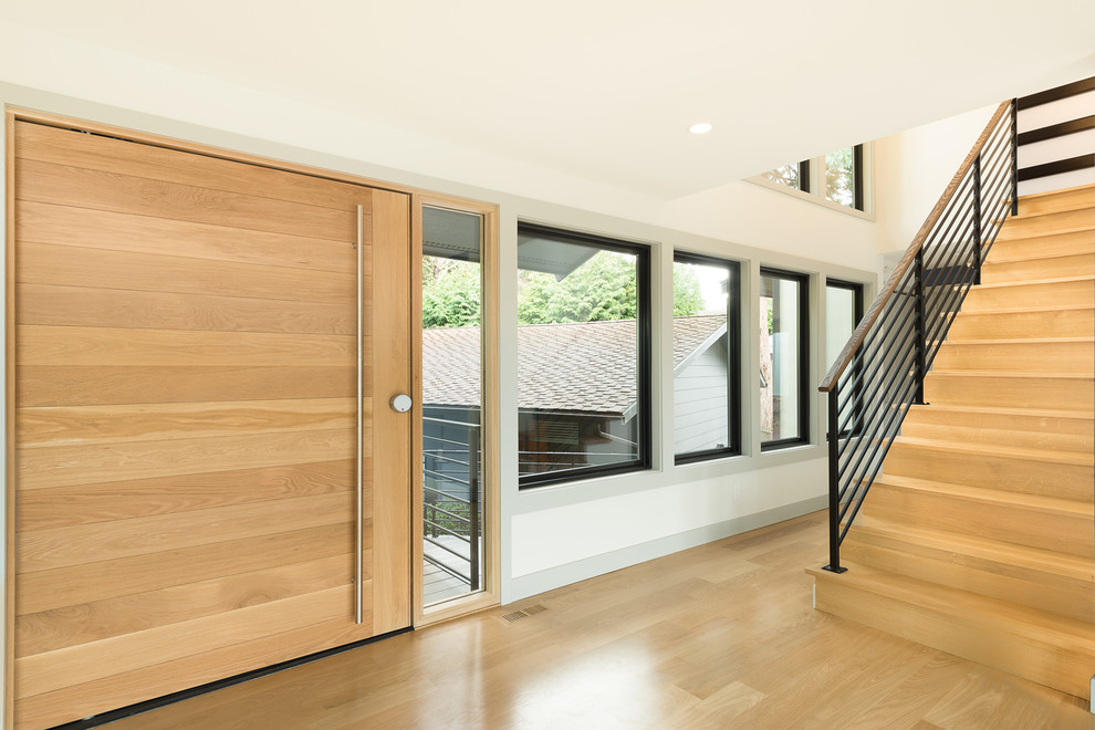 Front door - mid-sized transitional light wood floor and beige floor front door idea in Seattle with white walls and a light wood front door