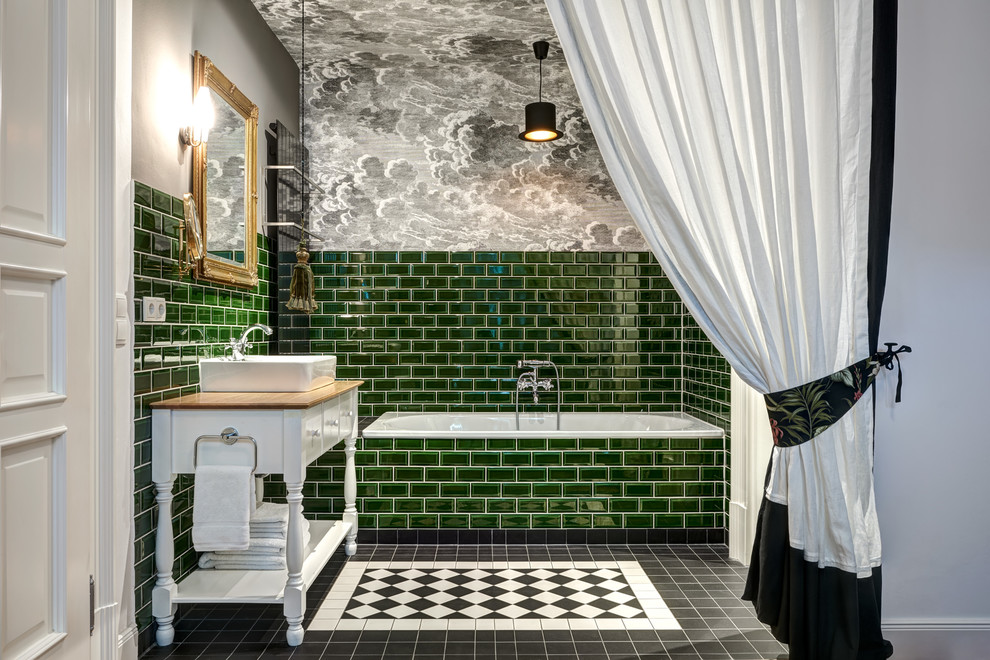 Inspiration for a mid-sized traditional master bathroom in Berlin with recessed-panel cabinets, white cabinets, a drop-in tub, a shower/bathtub combo, green tile, subway tile, grey walls, a vessel sink, wood benchtops, black floor and brown benchtops.