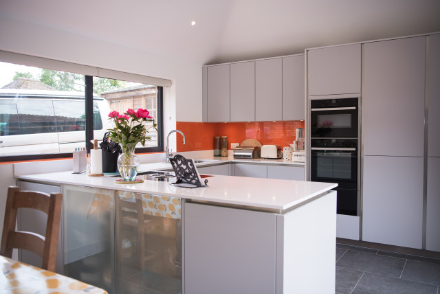 Handleless Grey Kitchen with Orange Splashback moderne-koekken